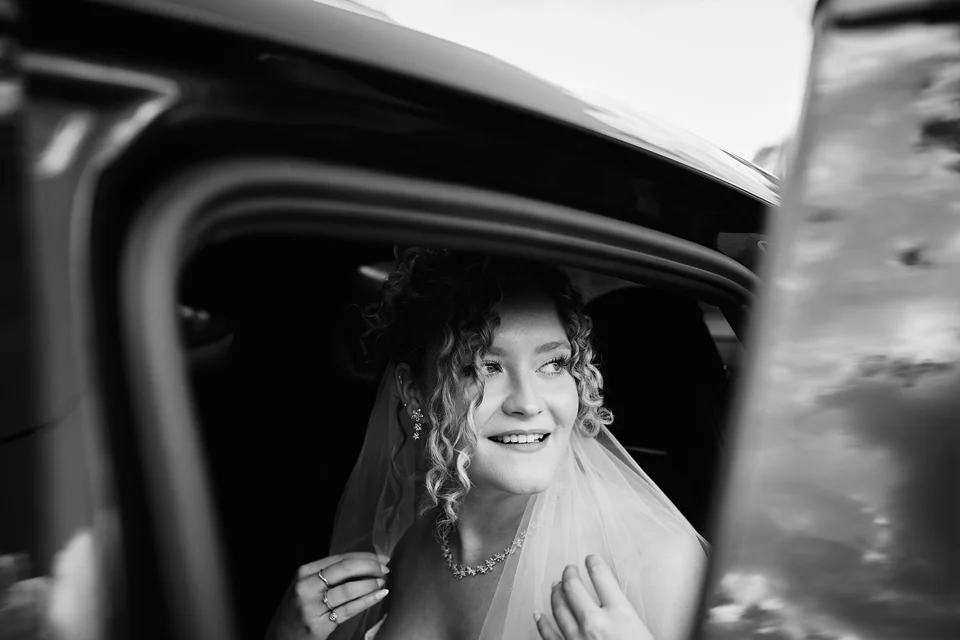 The bride in the wedding car, in black and white