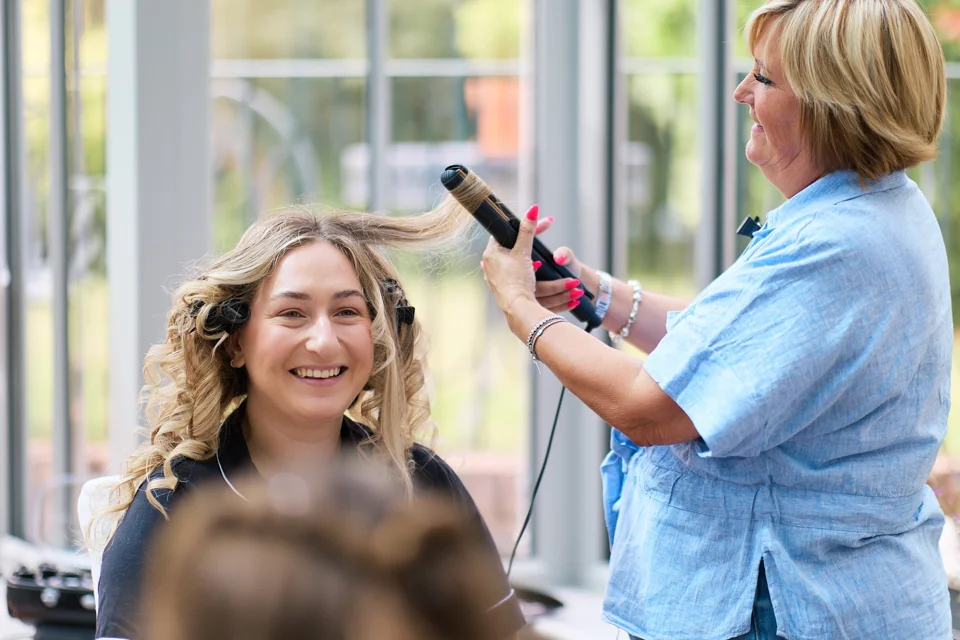 The bride smiling during hair preparations