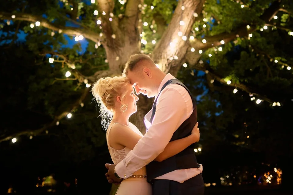 Eden and Aaron beneath illuminated trees at Thursford