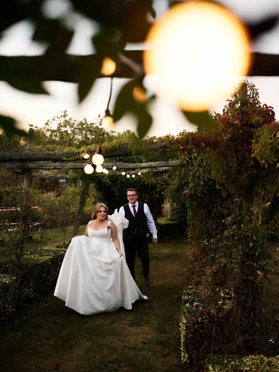 The couple beneath hanging lights in the garden